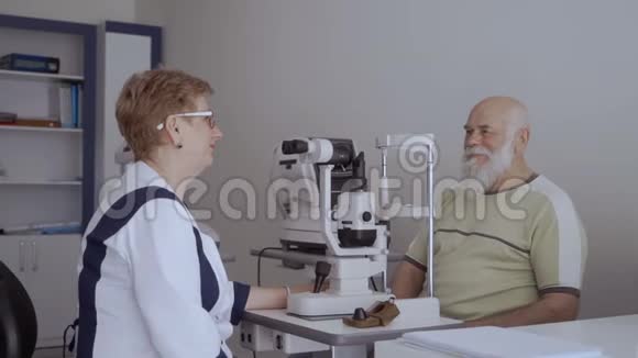 眼科医生和老人看镜头男人伸出大拇指视频的预览图