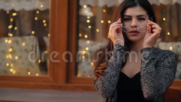 一位戴着眼镜的商务女性坐在一家开放的城市咖啡馆里的慢镜头肖像视频的预览图