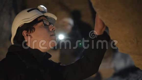 人类学家在洞穴的石灰墙上探索视频的预览图