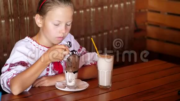快乐的微笑少女孩子在咖啡馆吃冰淇淋她穿着乌克兰民族服装刺绣视频的预览图