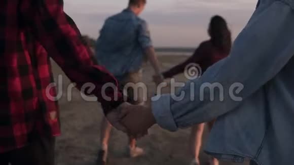 幸福的男女夫妇在一片荒凉的海滩上散步牵着手黄昏的天空两人步行视频的预览图