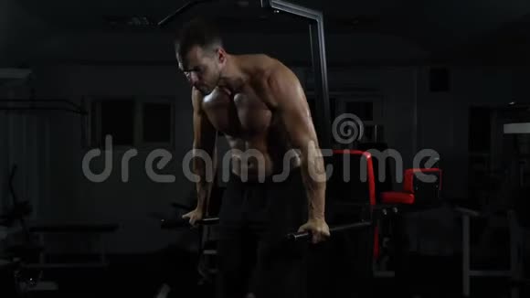 肌肉男在交叉健身馆的高低杠上做俯卧撑视频的预览图
