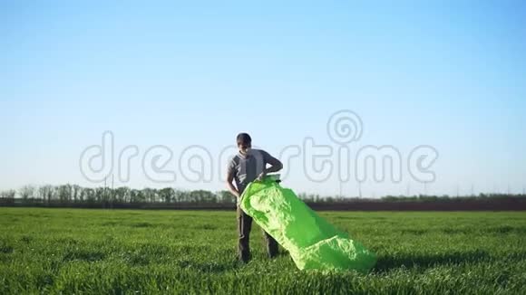一个人正试图迎风做充气床绿色美丽的草地视频的预览图