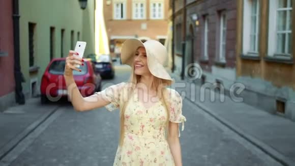 女人在街上自拍活泼开朗的年轻女子走在欧洲的老街上自拍视频的预览图
