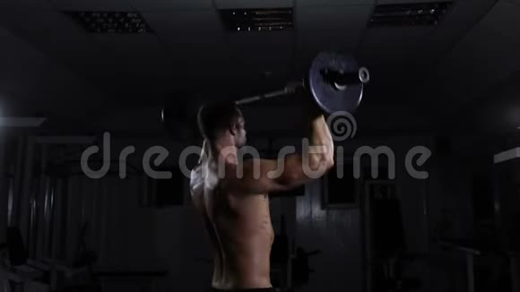 肌肉男在健身房用杠铃训练他用三角肌视频的预览图