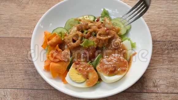 伊斯兰色拉蔬菜和煮鸡蛋打在脆炒芋头上调味甜豆酱清真食品用叉子刺在盘子上视频的预览图