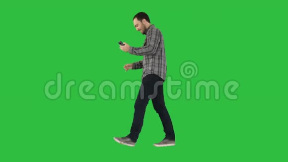 有吸引力的男人与短深色头发检查图片后自拍在绿色屏幕铬键视频的预览图