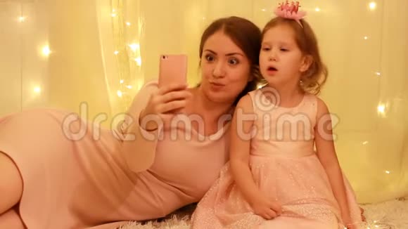 母亲带着小女孩在手机上为Selfie摆姿势视频的预览图