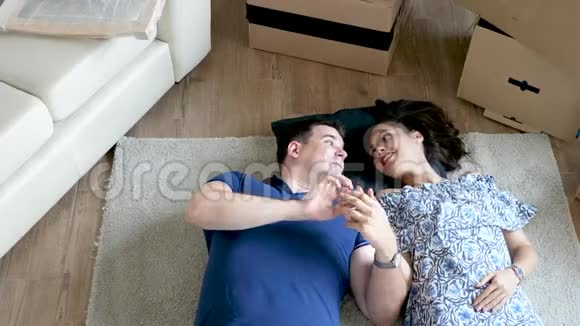 一对夫妇在他们新家的地板上休息视频的预览图