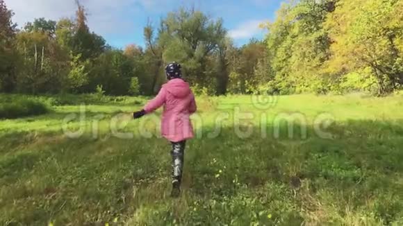 秋天森林里孤独的少女漫步在秋天的公园里视频的预览图