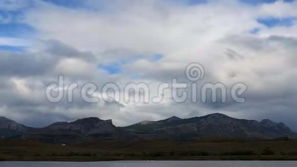 在灰色云层背景下的山脉山之间山谷中的清新湖泊最佳海岸景观视频的预览图