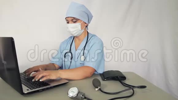 女医生坐在他的办公桌前用笔记本电脑工作摄像机移动到杜莉视频的预览图