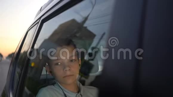 带着耳机听着车后座的音乐看着远处的少年视频的预览图