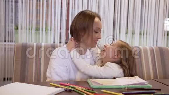 年轻的母亲和迷人的小女儿偷偷地在耳边低语着什么视频的预览图
