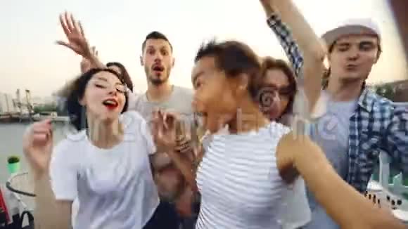 快乐的年轻男女朋友正在跳舞举手在夏天的屋顶聚会上玩得很开心现代生活方式视频的预览图