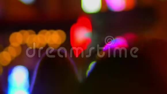 傍晚五颜六色的城市灯光背景下快速行走的行人的轮廓模糊拍摄视频的预览图