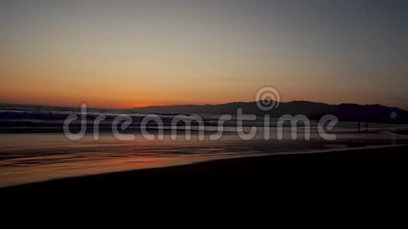 加利福尼亚太平洋海岸的日落冲浪者和慢跑者都在做一项运动视频的预览图