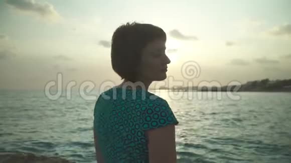 成年妇女在热带海岸散步日落时分视频的预览图