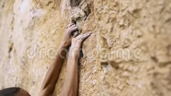年轻的女性攀岩者试图爬上悬崖寻找伸手和抓住视频的预览图
