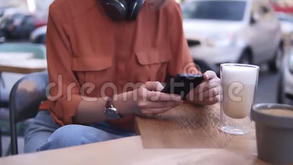 一个漂亮的金发女孩戴着一束头发和眼镜坐在街上的一家咖啡馆里旁边是她视频的预览图
