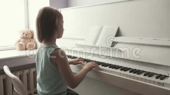在家学习弹钢琴的小女孩学龄前儿童玩音乐乐器视频的预览图