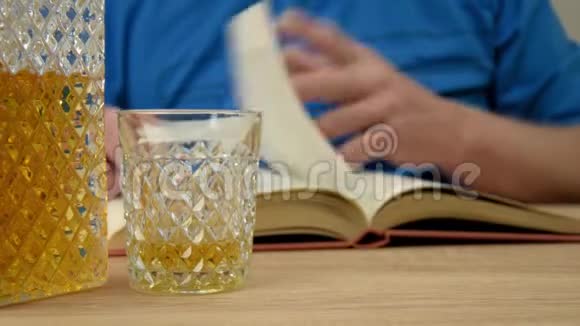 酒精饮料在水晶蜕膜一个人手里拿着一杯倒了一杯威士忌饮料用眼镜打开书视频的预览图