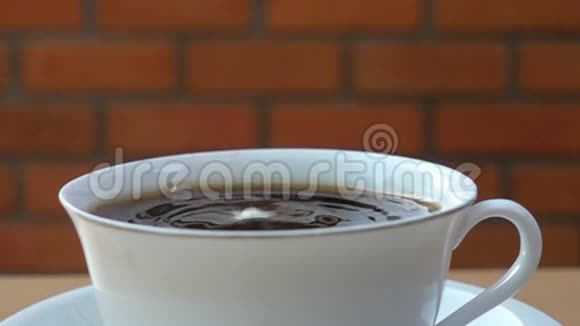 把新鲜牛奶放在木桌上的一杯咖啡里视频的预览图