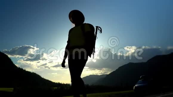 旅行者的女人带着一个红色的背包沿着路走山区康特罗维灯视频的预览图