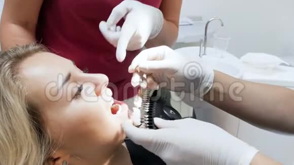 牙科医生在美白前检查病人牙齿颜色的4k镜头视频的预览图