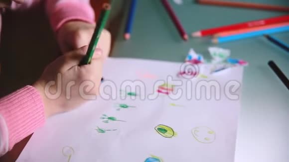 镜头从小白种人的学龄前女孩手中滑落用彩色铅笔在一张桌子上画动物视频的预览图