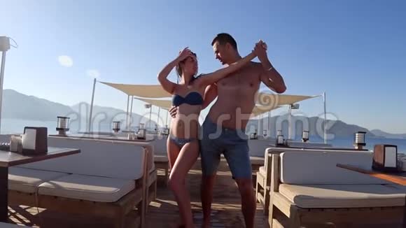 在度假胜地的海边码头情侣们激情的舞蹈变成泳装视频的预览图