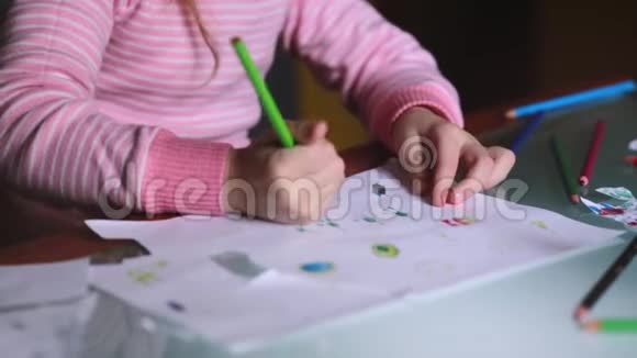 一个可爱的白种人小女孩的特写镜头她学会用手拿着铅笔在家里的桌子上画纸视频的预览图