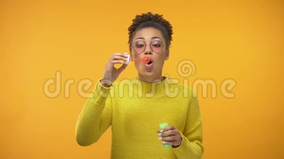 兴奋的非裔美国女孩吹着肥皂泡孩子气快乐视频的预览图