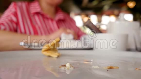 吃完食物后倒空盘子背景上的女人手里拿着一杯茶喝着近距离射击视频的预览图