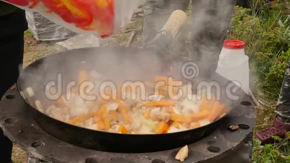 在户外用肉烹饪蔬菜在大锅里炒蔬菜假期康塞普特烟慢慢地从上面升起视频的预览图