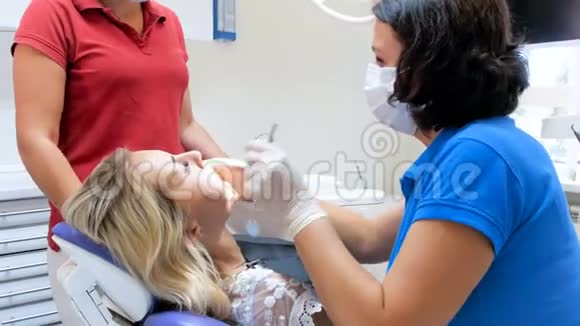 牙科医生使用特殊镜子检查病人口腔的4k镜头视频的预览图