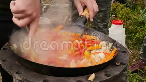 在户外用肉烹饪蔬菜在大锅里炒蔬菜假期康普特烟慢慢地从上面升起视频的预览图
