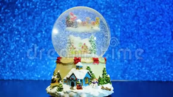 带雪花的圣诞雪球蓝色模糊闪光背景上的新年玻璃纪念品视频的预览图