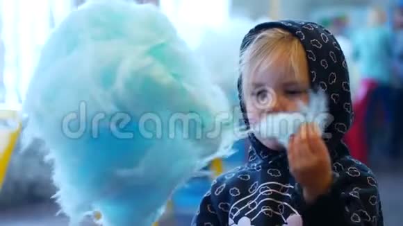 兜帽里的小女孩在马戏团吃蓝色棉花糖视频的预览图