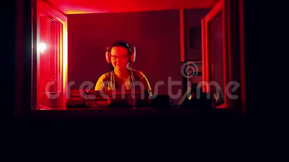 收音机里戴着耳机的女DJ在混合控制台拿着迪斯科视频的预览图