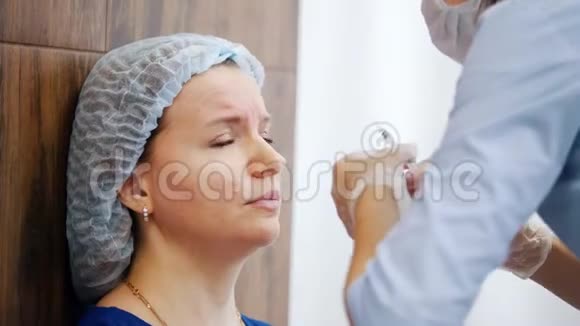 美容诊所的女人专科医生在病人前额扎针视频的预览图