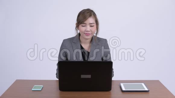 年轻快乐的亚洲女商人在工作时笔记本电脑视频的预览图