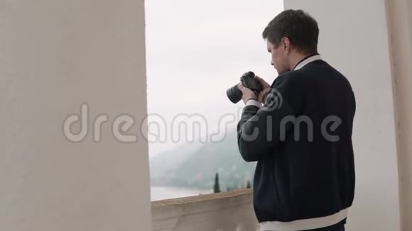 男摄影师正在镜头中观看风景视频的预览图