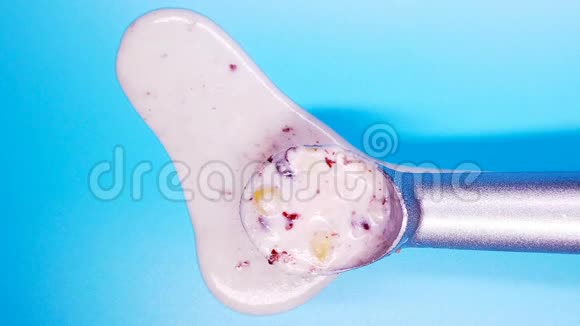 将栗子和红豆冰淇淋球在蓝色背景上的勺子上翻转视频的预览图