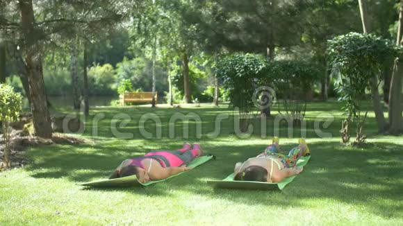 健身女性在大自然的瑜伽垫上健身视频的预览图