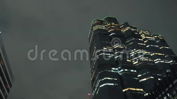 市中心夜晚的塔顶天空背景下照亮摩天大楼视频的预览图
