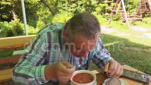 男人在户外夏日咖啡馆喝汤视频的预览图