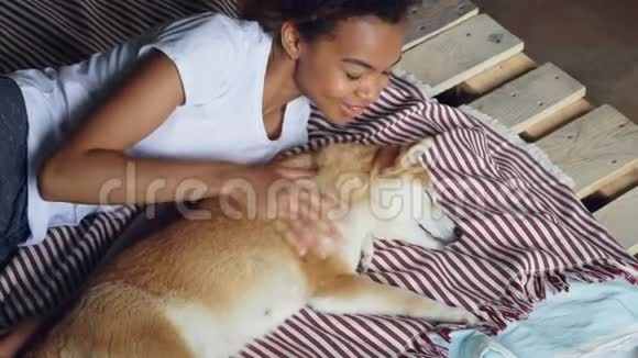 笑着说美国黑人女孩正在醒来她正在睡觉在狗狗的时候她的狗在大惊小怪和它说话视频的预览图
