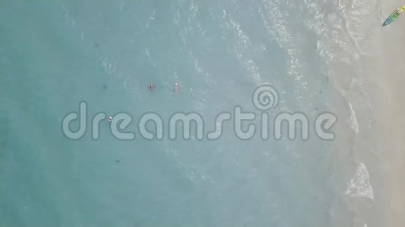 人们在蓝色的大海里游泳皮艇躺在沙滩上从无人驾驶游客的空中俯瞰视频的预览图