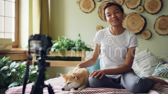 情感女孩成功的博客作者正在为她的在线博客录制视频她坐在现代公寓的床上抚摸着视频的预览图